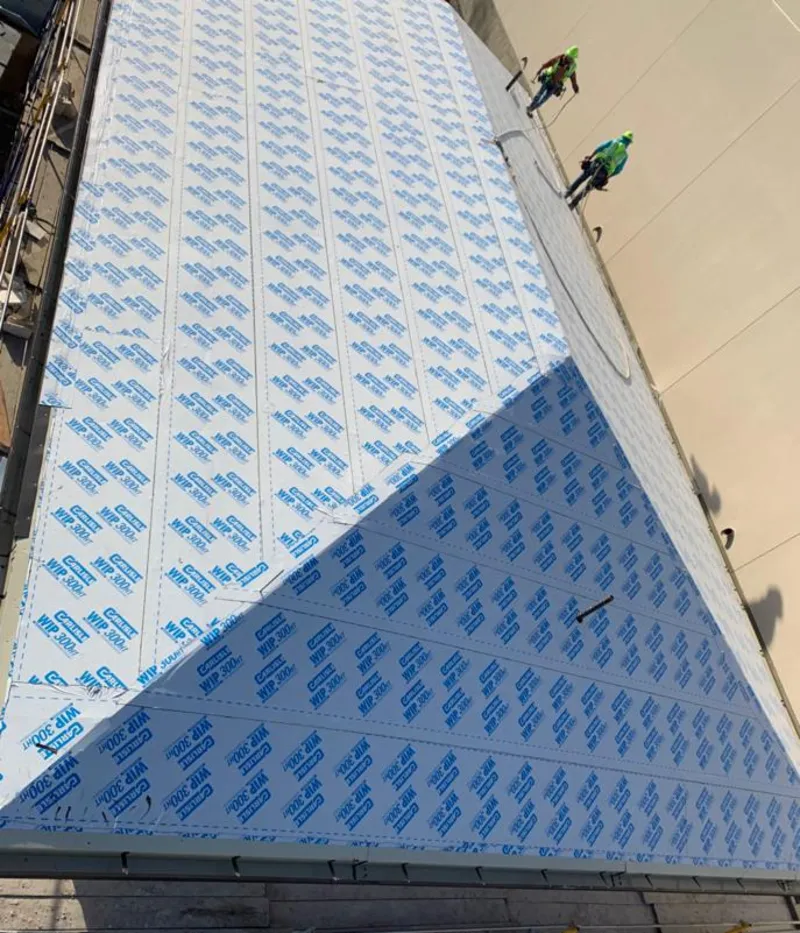 Professional roofers installing underlayment on a metal roof in Jaffrey